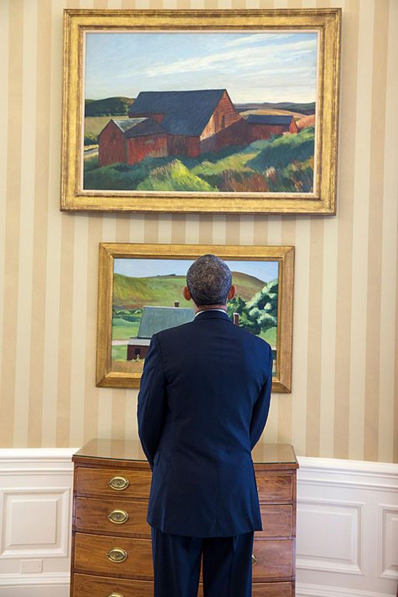 President Barack Obama looks at the Edward Hopper paintings now displayed in the Oval Office, Feb. 7, 2014. The paints are Cobb's Barns, South Truro, top, and Burly Cobb’s House, South Truro. (Official White House Photo by Chuck Kennedy)