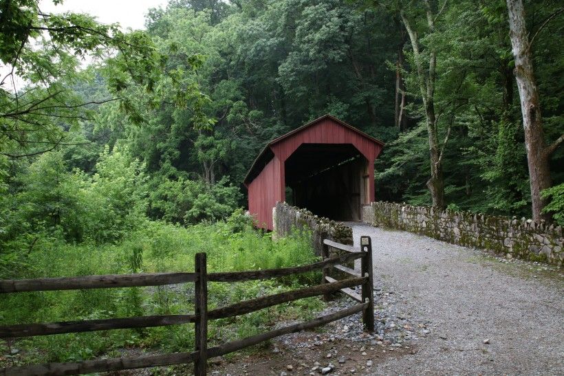 Red covered bridge surrounded by greenery at the Brandywine's Laurels Preserve