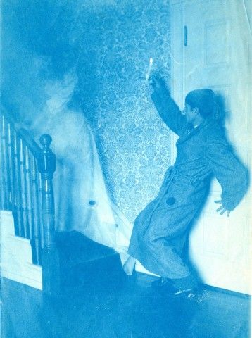 A double-exposure photograph in the scrapbook, possibly featuring Maxfield Parrish, in a staged encounter with a ghostly figure.