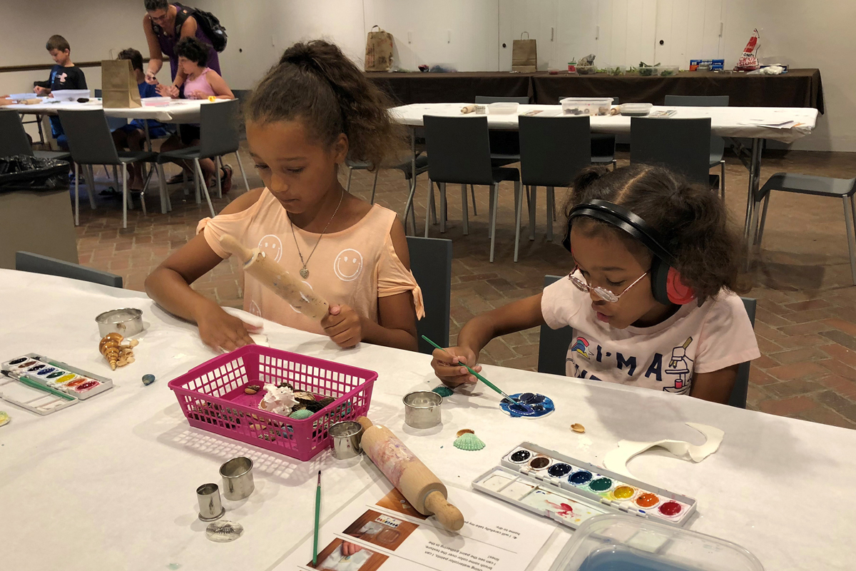 Two girls painting art projects during a Sensory Saturday program.