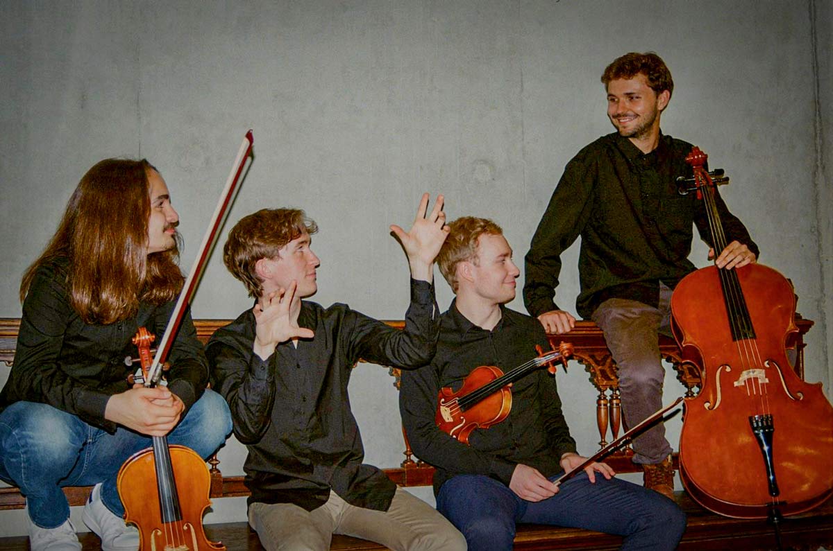 Four musicians talking with violins and cello