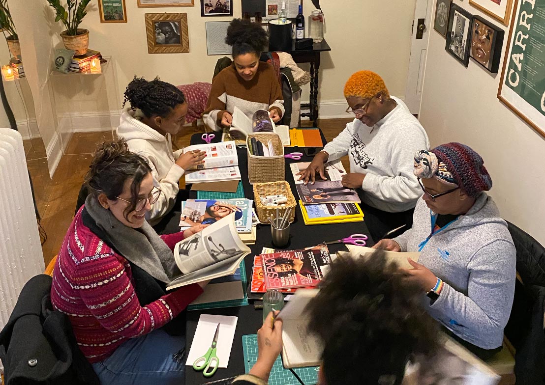 Group of adults around a table working on an art activity.