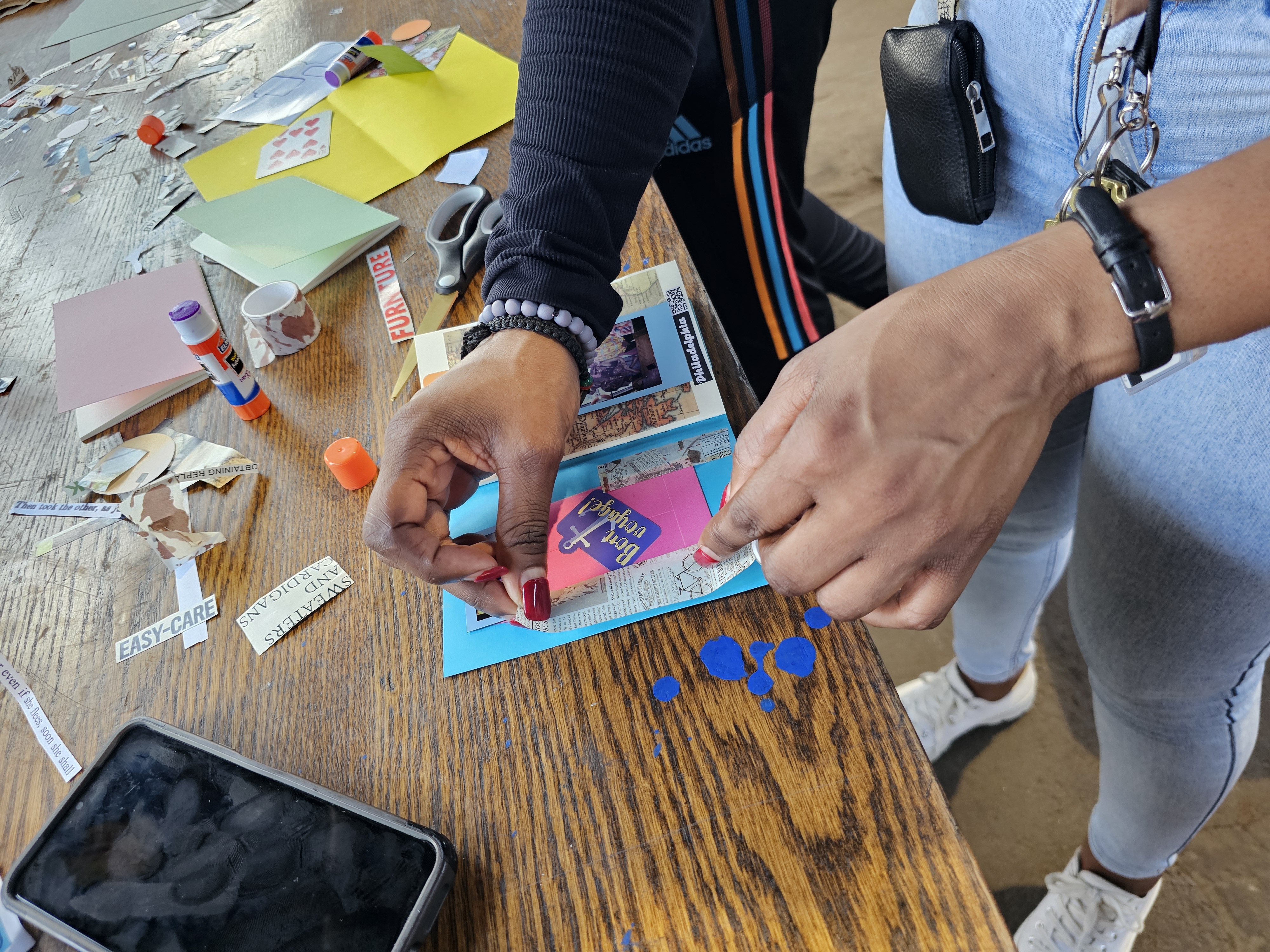 Up close shot of a person hands gluing piece of paper together and making a collage