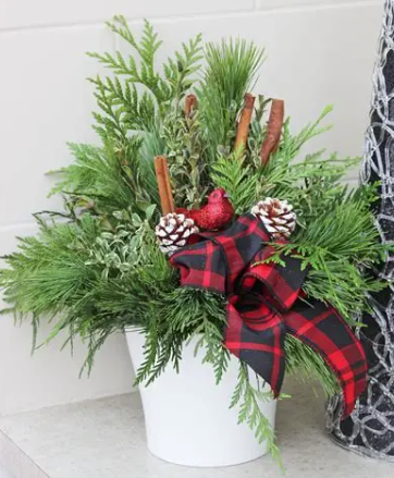 Table top arrangement, made of evergreen branches tied together with a red bow