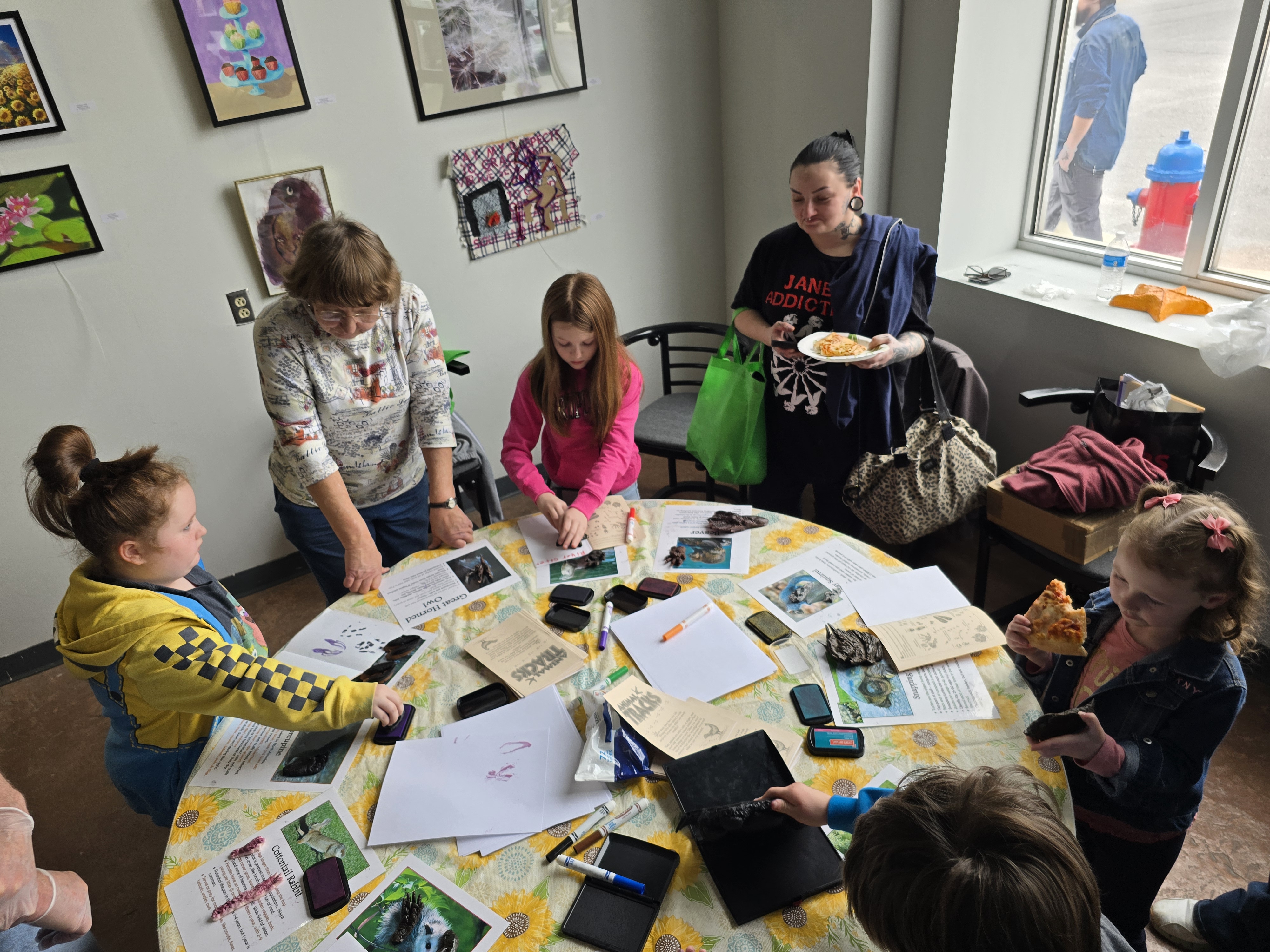 Image of people standing around a circular table crafting.