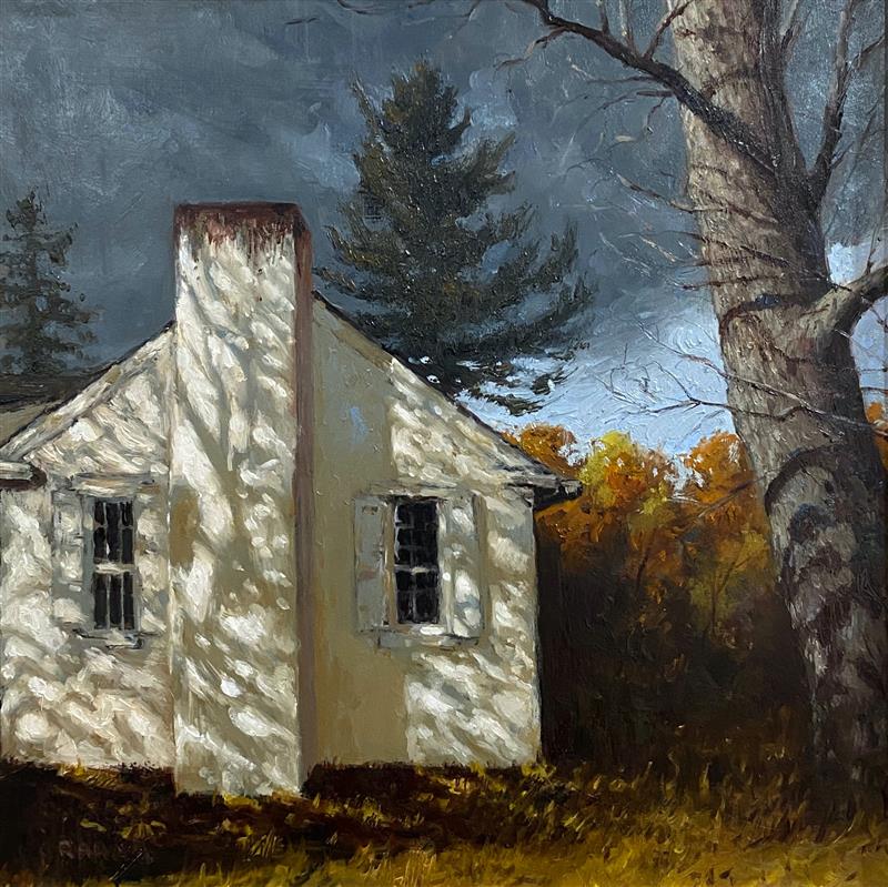 A small, pale house with a tall chimney sits in a quiet rural setting, dappled with sunlight filtering through nearby trees. Behind and beside it, tall trees with autumn-colored leaves stand under a moody, gray-blue sky, giving the scene a calm but slightly somber feeling.