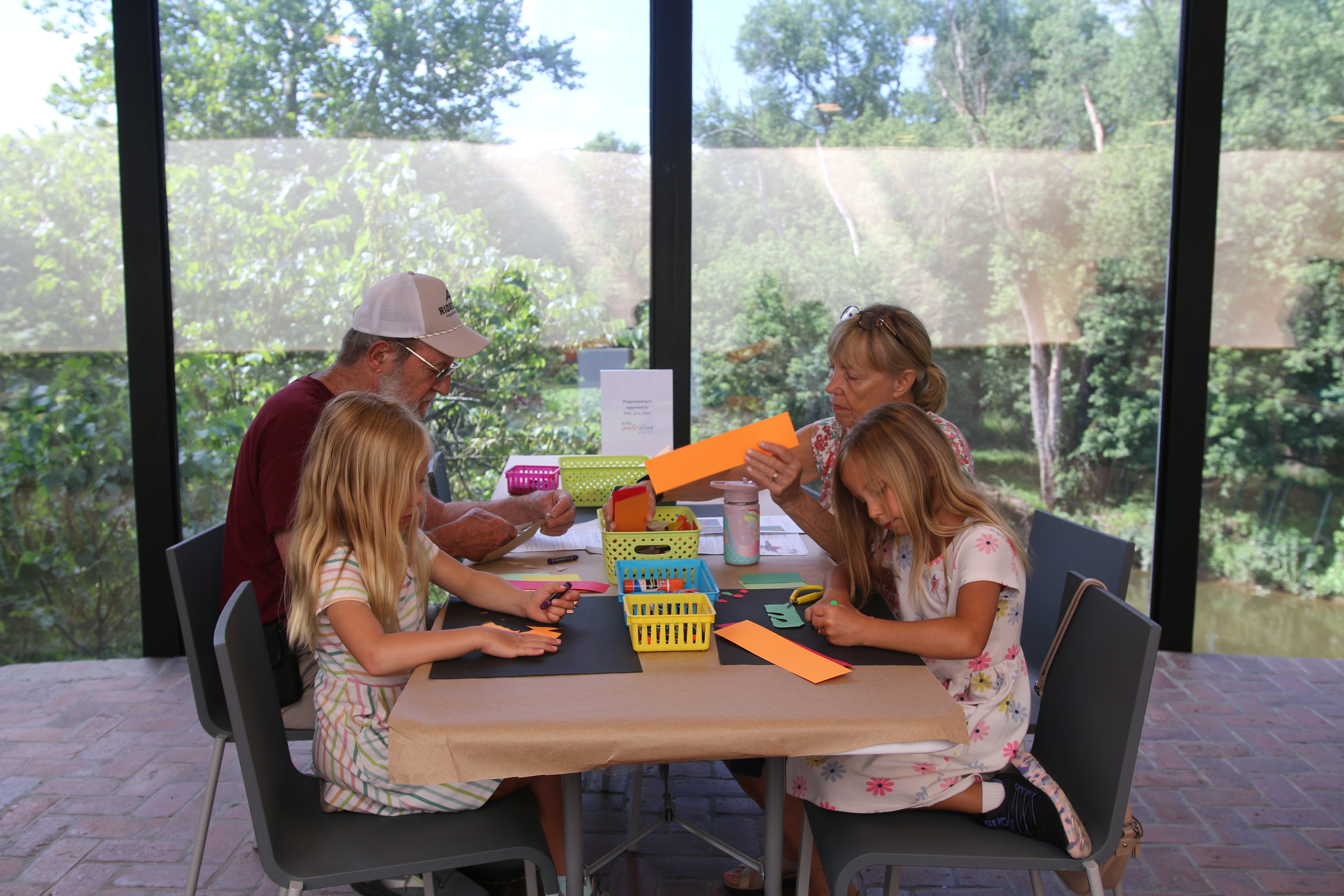Kids and adults sitting at a table making art