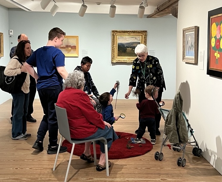A group of people seated admiring artwork.