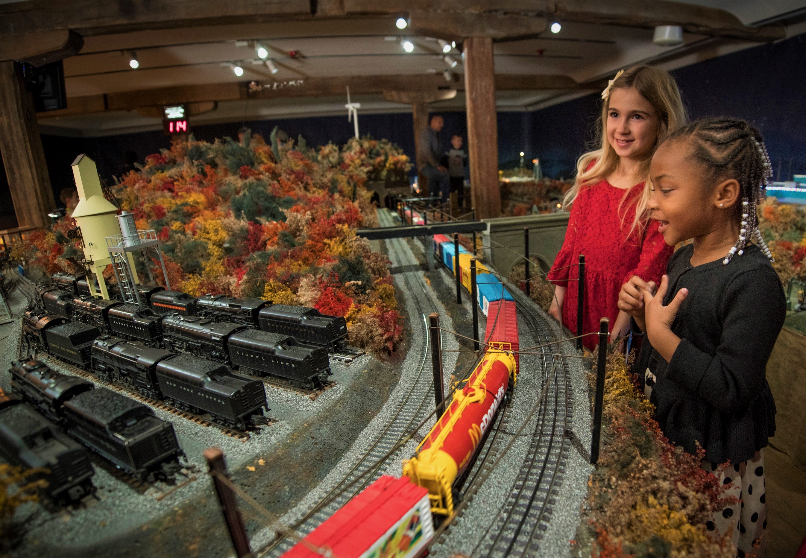 Girls smiling at the holiday train display during Brandywine Christmas at the Brandywine River Museum of Art