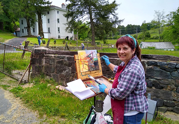 woman painting outside at a farm