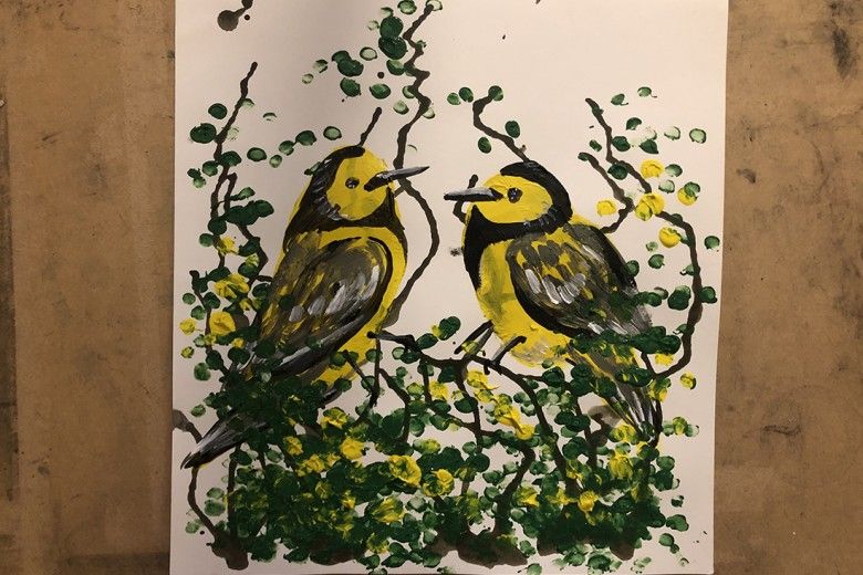 Two yellow painted birds made using a potato-printing technique