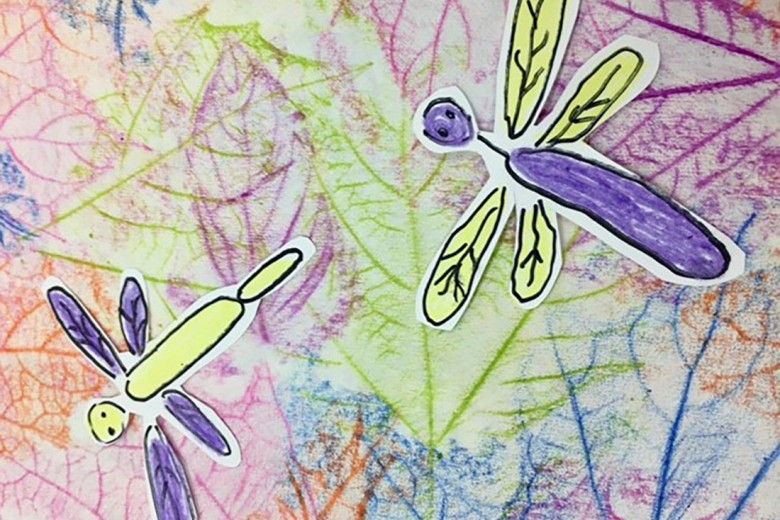 Finished example of a colorful leaf rubbing artwork with cutout paper dragonflies on top