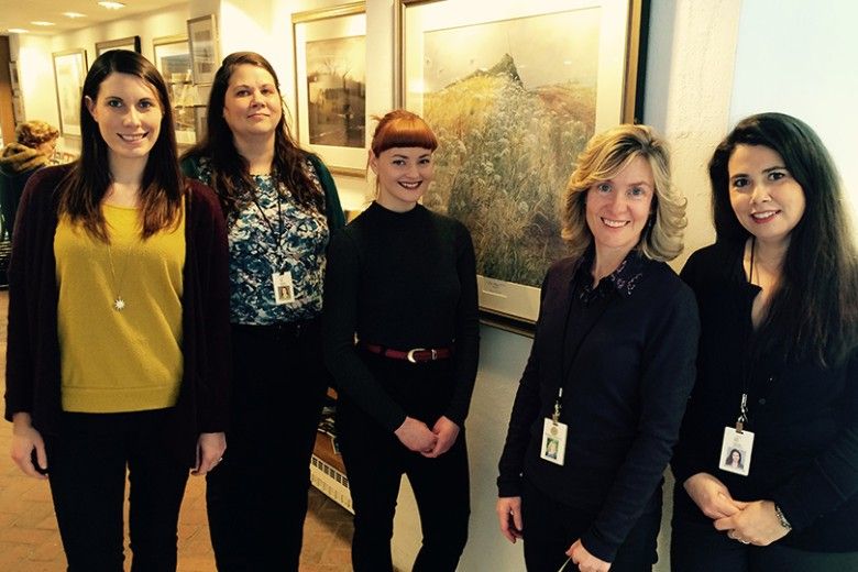 shop staff in front of August print