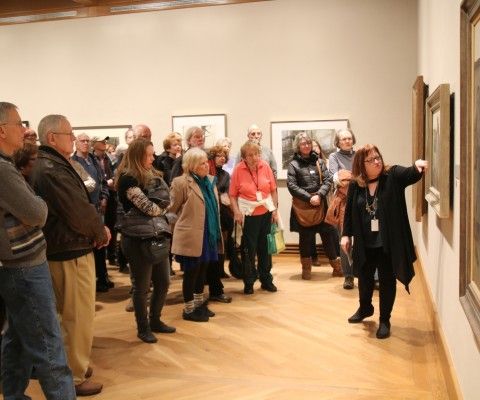 A group of people looking at art in a Museum gallery