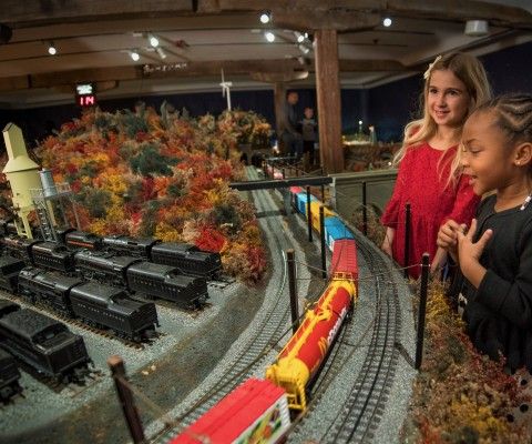 Girls smiling at the holiday train display during Brandywine Christmas at the Brandywine River Museum of Art