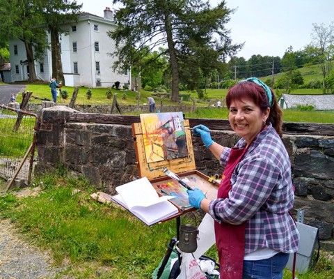 woman painting outside at a farm