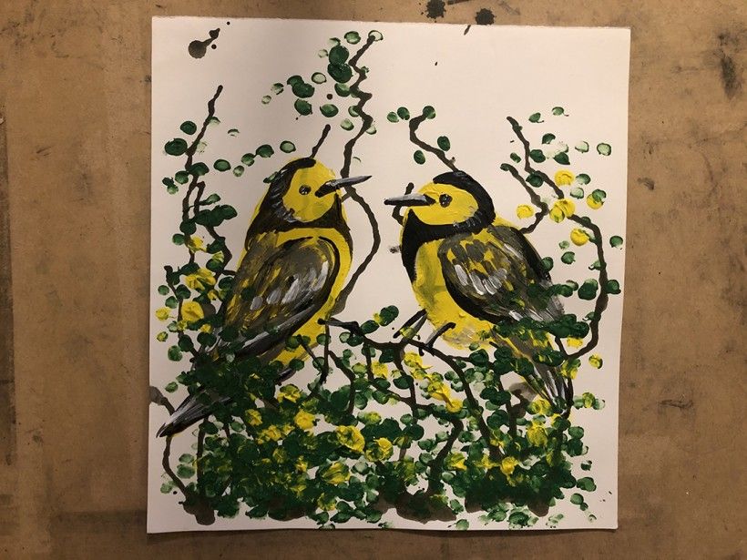 Two yellow painted birds made using a potato-printing technique