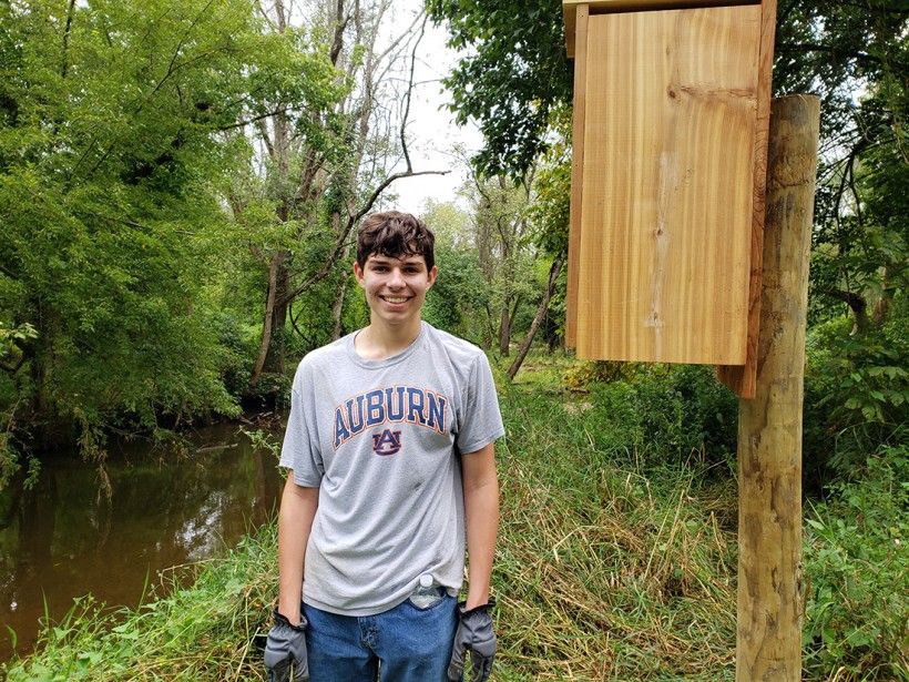 Eagle Scout standing next to nesting box at Waterloo Mills Preserve