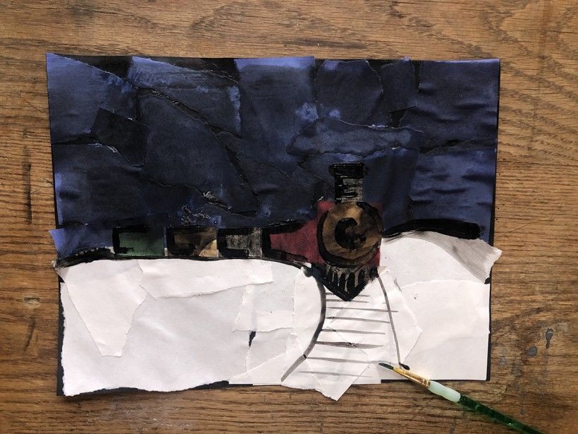 Black paint outlining details of the nighttime train scene made of construction paper