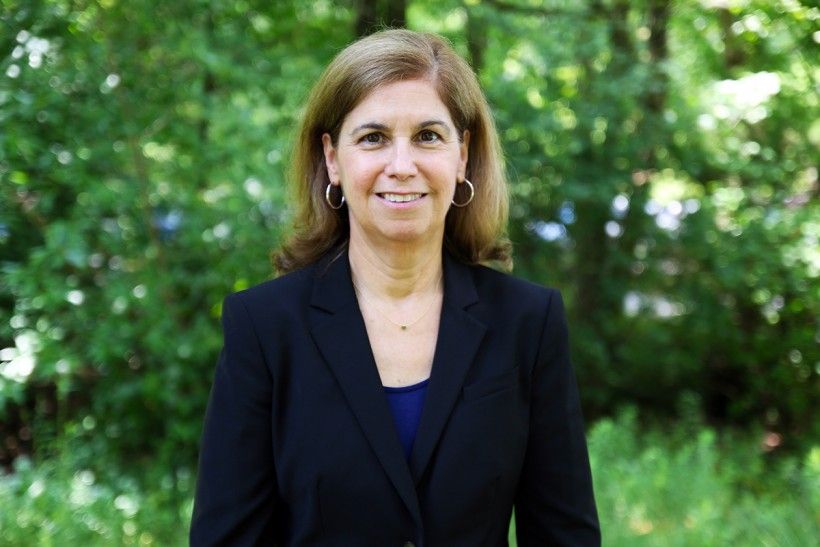 Photo of Ellen Ferretti, outside with green trees in the background