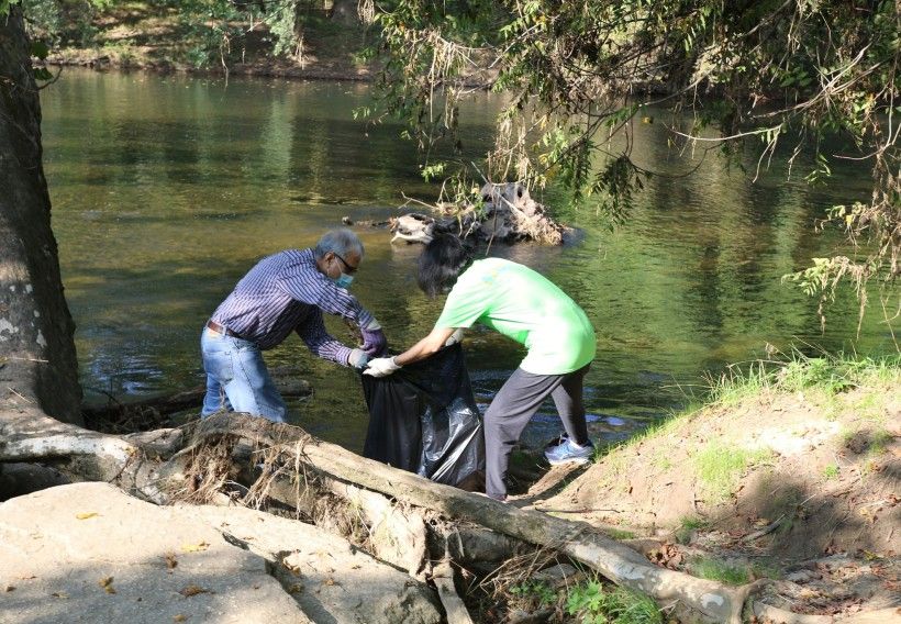 Photo of two people cleaning up trash along the Brandywine Creek