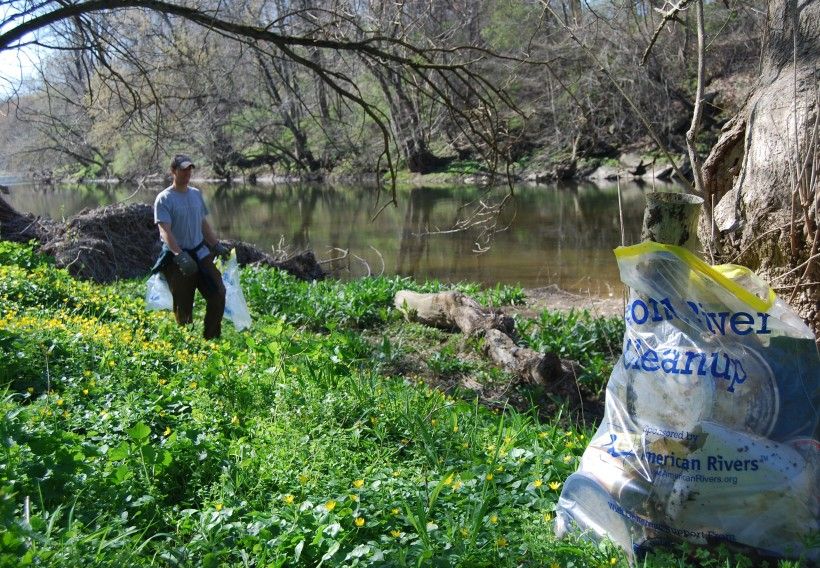 Photo of a person cleaning up trash along the Brandywine Creek.