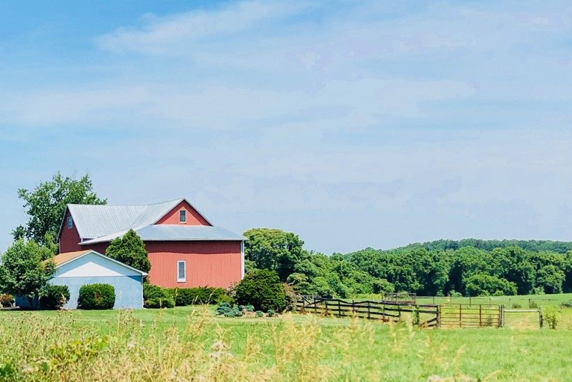 Wide view of a farm found in London Britain township in Pennsylvania, complete with a red house and a wooden fence