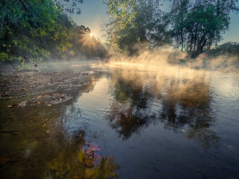 Close up shot of the Brandywine Creek with the sun near the center of the frame