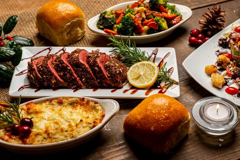 Photo credit: Jed Owen photo of a holiday dinner spread with a roast, casserole and roasted vegetables
