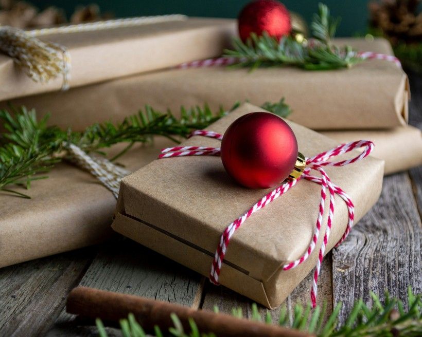 Photo credit: Mel Poole photo of brown paper wrapped Christmas presents tied with string.