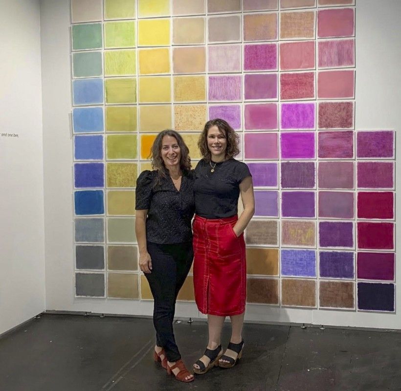 Two women standing in front of artwork