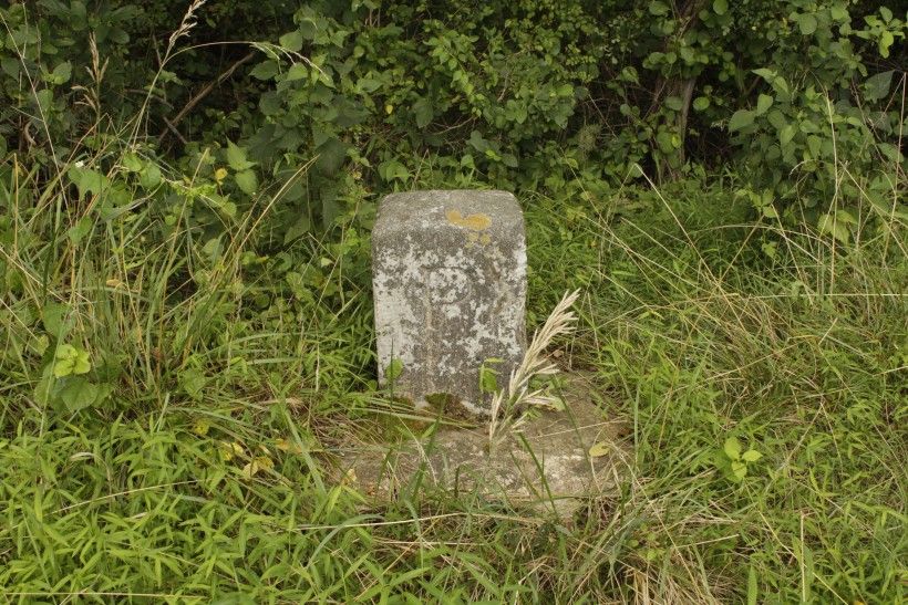 Stone mile marker sitting in a field