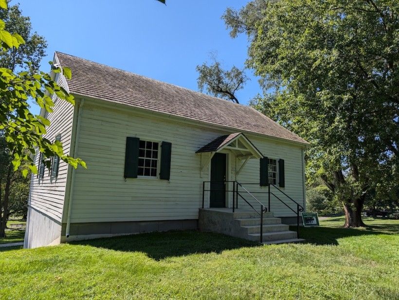 Lyceum Building in New Garden Township Park. Credit: Beth Burns A white house, surrounded but lush green trees and lawn
