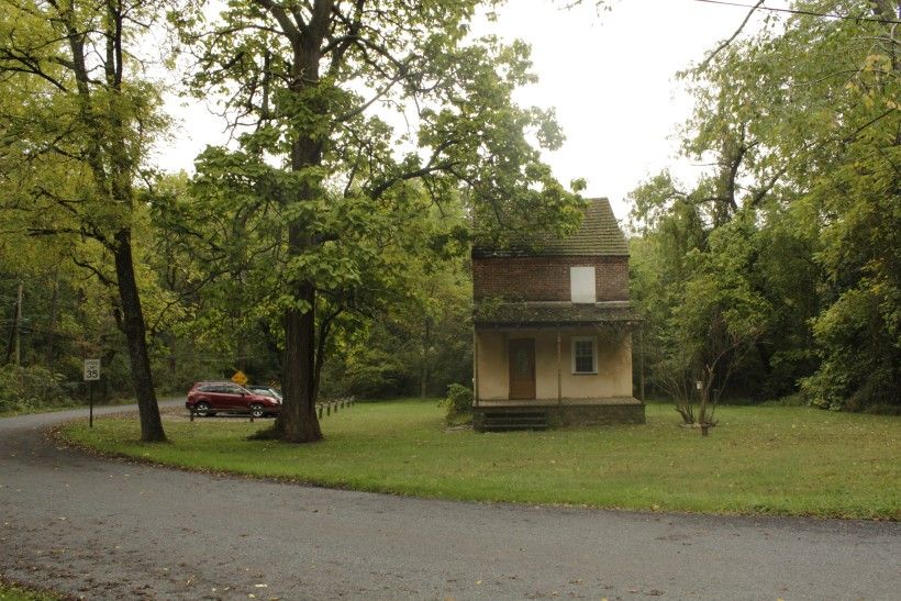House sitting in a field surrounded by trees