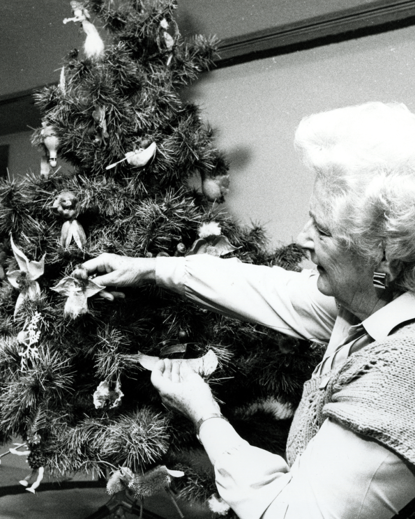 Woman putting ornaments on a Christmas tree