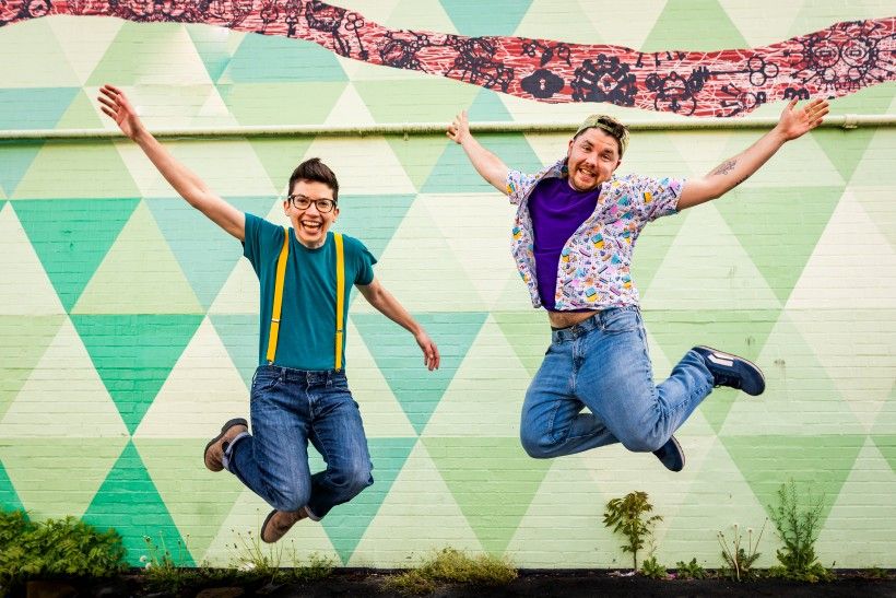 Two people jumping in the air with their hands up