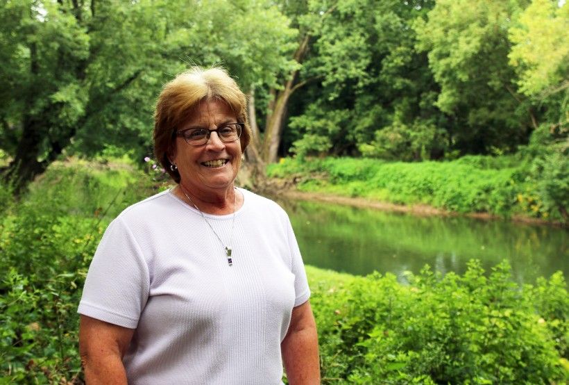 Jan Bowers standing alongside the Brandywine River