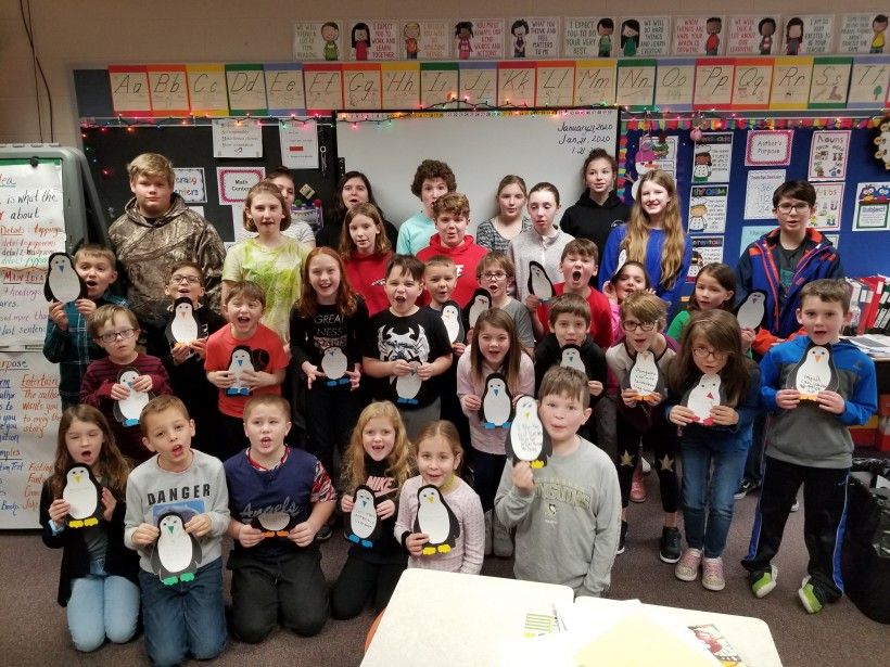 Laurel Valley Middle School students line up behind a class of second graders, who are displaying the penguins they made, at R.K. Mellon Elementary School.