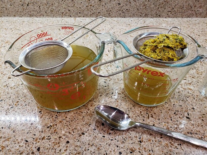 Pressing the dandelion flowers through a mesh strainer