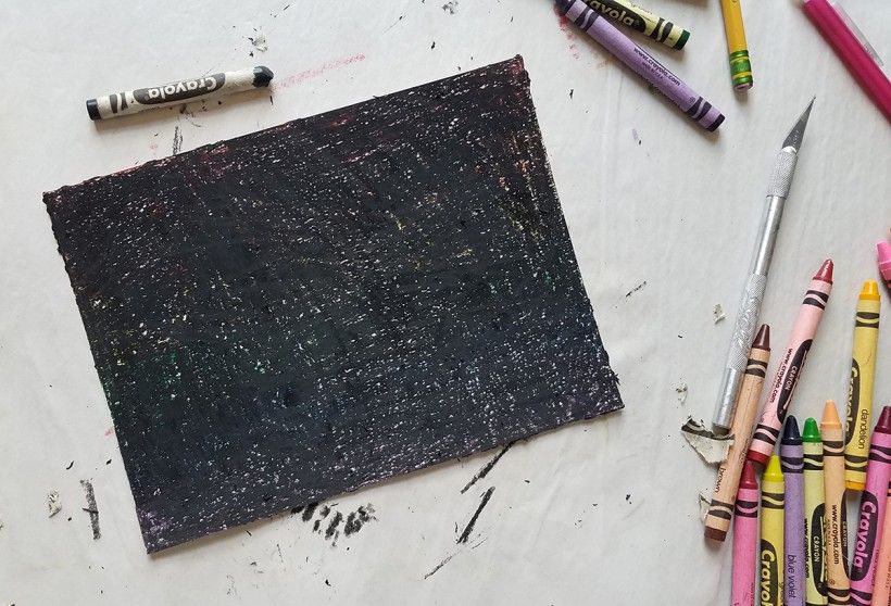 A piece of paper colored over with black crayon
