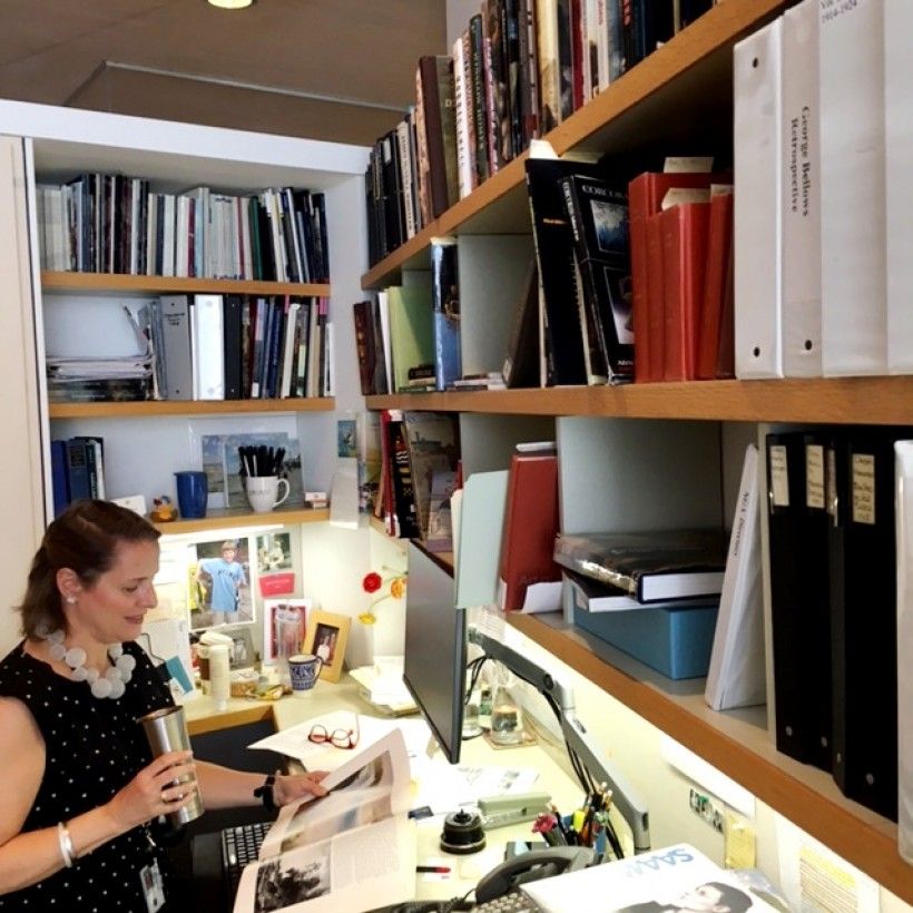Curator Sarah Cash drinking coffee in her office