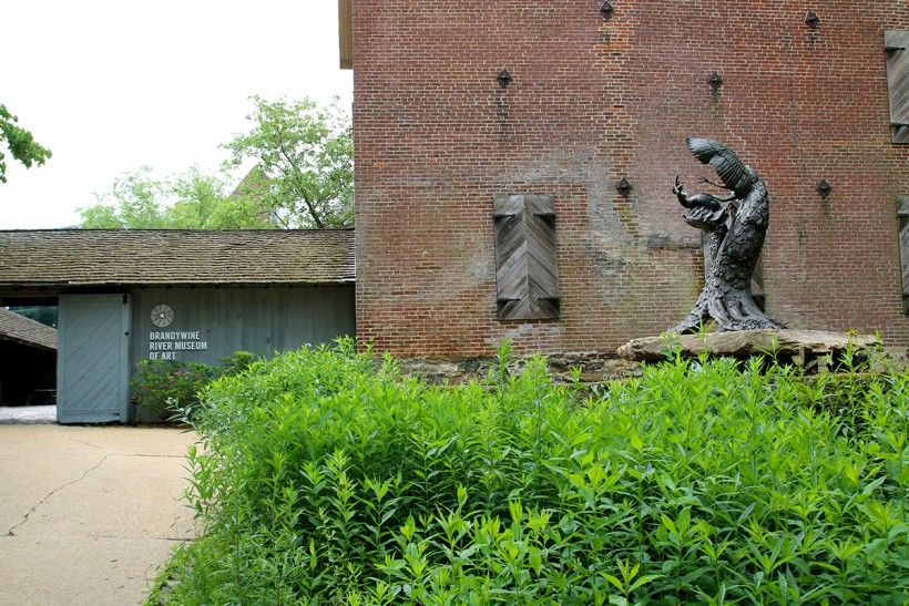 Bronze sculpture of two life-size fighting peacocks in front of the Brandywine's main entrance