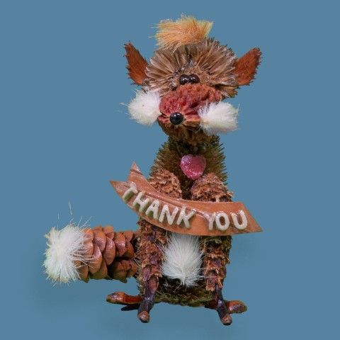 A critter holding a thank you sign with a blue background.