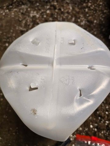 Photo credit: Melissa Reckner photo of the bottom of an empty milk jug with holes punched in it for drainage