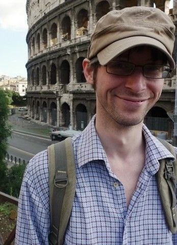 Photo of a man wearing a hat and glasses.