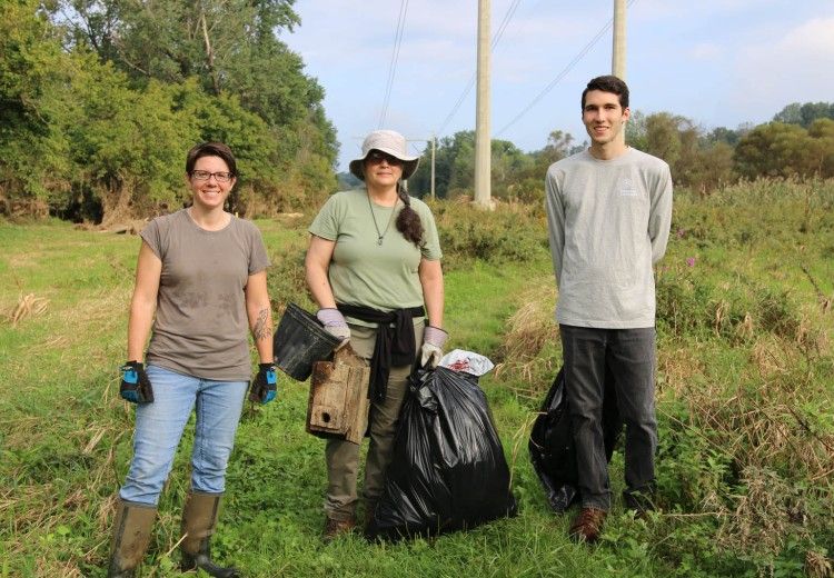 Three volunteers at a river clean up