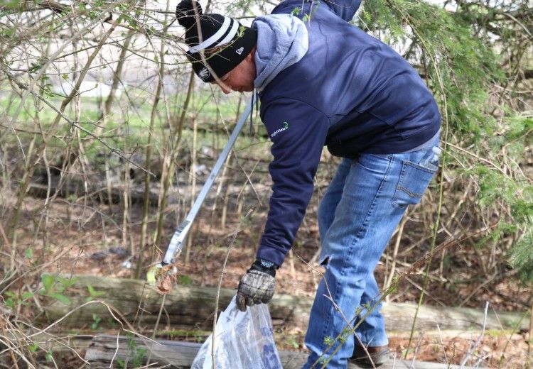 A volunteer cleaning up trash in nature